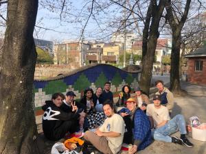 een groep mensen die poseren voor een foto onder een boom bij MAKOTO GUESTHOUSE -Enjoy your stay- in Tokyo