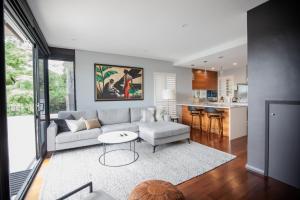 a living room with a couch and a table at PHOE1-3B - Harbour Haven Townhouse in Sydney