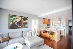 a living room with a couch and a kitchen at PHOE1-3B - Harbour Haven Townhouse in Sydney