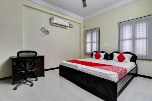 - une chambre avec un lit, un bureau et une chaise dans l'établissement OYO Shri Inn, à Vijayawada