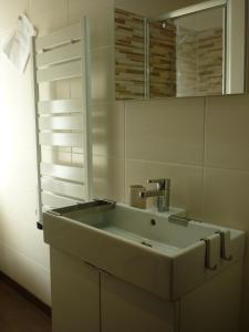 een badkamer met een wastafel en een spiegel bij Les Myosotis in Les Deux Alpes