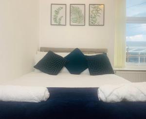 Schlafzimmer mit einem Bett mit blauen und weißen Kissen in der Unterkunft WHOLE HOUSE, Near Bury Town Centre Manchester , 3 Bedrooms, 3 En-suite House, Free Parking, Wi-Fi, Sleeps 5 in Bury