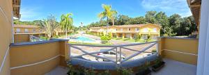 - un balcon offrant une vue sur une maison avec piscine dans l'établissement VILLAGIO CHARMOSO NA PRAIA DA MOCOCA, à Caraguatatuba