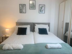 two beds in a bedroom with two pillows at WHOLE HOUSE, Near Bury Town Centre, 3 Bedrooms, 3 En-suite House, FREE Parking, Wi-Fi, Sleeps 5 in Bury