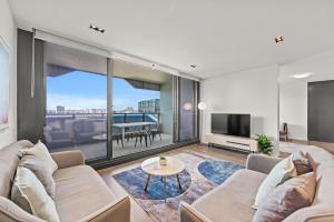 a living room with a couch and a tv at Fortitude Valley Apartments by CLLIX in Brisbane