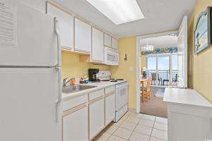 a kitchen with white cabinets and a white refrigerator at North Myrtle Beach 1BR Oceanfront Condo at Bay Watch in Myrtle Beach