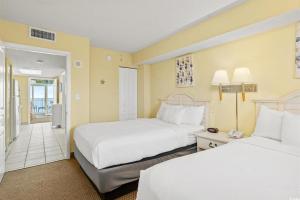 a hotel room with two beds and a hallway at North Myrtle Beach 1BR Oceanfront Condo at Bay Watch in Myrtle Beach +14 photos