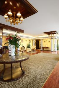 فندق لو رويال في الكويت: لوبي مع طاولة عليها إناء ورد