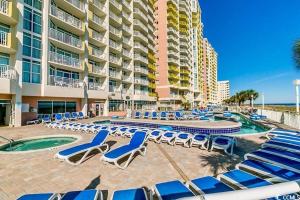 a resort with lounge chairs and a pool and a building at North Myrtle Beach 1BR Oceanfront Condo at Bay Watch in Myrtle Beach