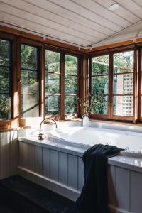 una grande vasca da bagno in una stanza con finestre di Waterfalls a Basket Range