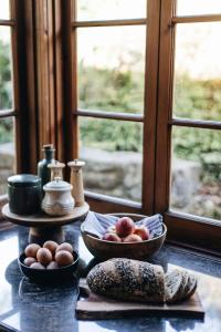 een tafel met appels en eieren naast een raam bij Waterfalls in Basket Range