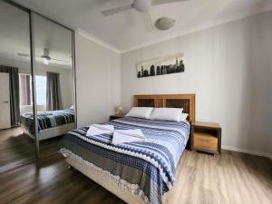 a bedroom with a bed and a large mirror at Unit 26 Seafront Estate in Jurien Bay