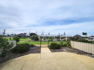 a fence and a walkway in a yard with houses at Unit 26 Seafront Estate in Jurien Bay