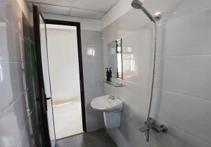 um banheiro com vaso sanitário, pia e chuveiro em Duc Hanh Apartment em Da Nang mais 40 fotografias