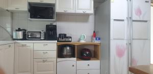 a small kitchen with white cabinets and a microwave at 더드림하우스 in Jeonju