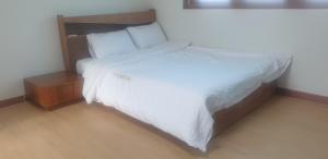a bed with white sheets and pillows in a room at 더드림하우스 in Jeonju
