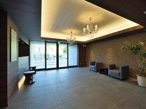 a lobby with a waiting room with chairs and a chandelier at Karry CONDO CHURAUMI in Motobu