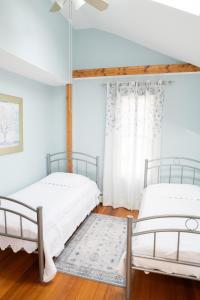 two beds in a room with white walls at Modern Beautiful Apartment-5 Beds-Full Kitchen-Parking-Super Clean-Great for Groups in Boston