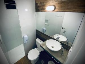 a bathroom with a toilet and a sink and a mirror at Sun Smart Hotel - in Recife