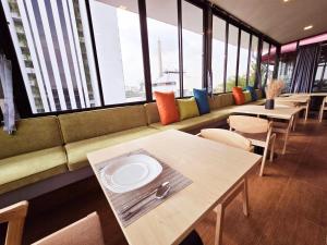 a dining room with tables and chairs and windows at Red Door Samsen Hotel, Bangkok in Bangkok +59 photos
