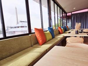 a row of benches in a restaurant with tables and windows at Red Door Samsen Hotel, Bangkok in Bangkok