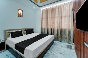 OYO Flagship Hotel Singh Residency في رانشي: غرفة نوم فيها سرير وتلفزيون