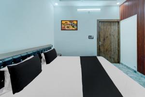 um quarto com uma cama e uma porta de madeira em OYO Flagship Hotel Singh Residency em Rānchī