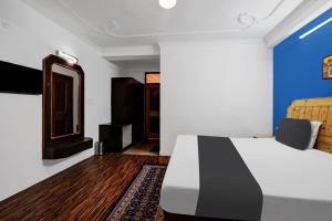 1 dormitorio con cama blanca y espejo en OYO Asha Cottage, en Manali