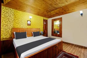 1 dormitorio con 1 cama grande en una habitación en OYO Asha Cottage, en Manali