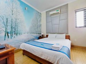 Schlafzimmer mit einem Bett und einem Wandbild von Bäumen in der Unterkunft Hotel Lê My in Cần Thơ