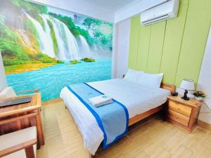 ein Schlafzimmer mit einem Gemälde eines Wasserfalls in der Unterkunft Hotel Lê My in Cần Thơ