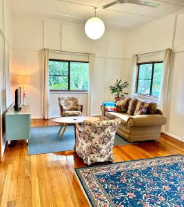 a living room with a couch and a table at Jindy's Cottage Atherton in Atherton