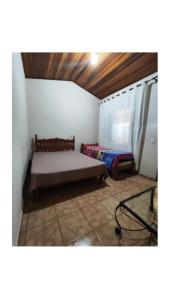 a bedroom with a bed in the corner of a room at Condomínio nogueira 2 in São João Batista do Glória