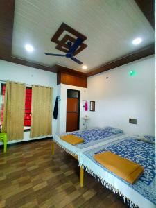 um quarto com 2 camas e uma ventoinha de tecto em Bhakti holiday home em Revadanda
