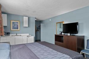 Holiday Lodge في ويناتشي: غرفة نوم بسرير وتلفزيون بشاشة مسطحة