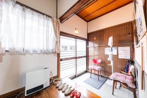 a room with a table and a chair and a window at Hostel みんか松本 in Matsumoto