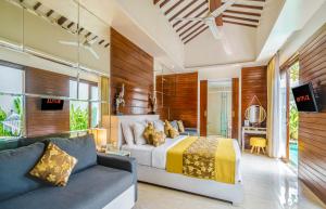 a bedroom with a bed and a couch at Anari Villas Kuta in Legian