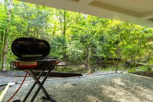 a grill on a stand in front of a forest at koti hakone（コティ箱根） in Hakone