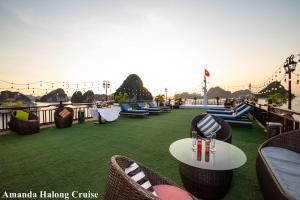 d'une terrasse avec des tables et des chaises sur l'eau. dans l'établissement Amanda Legend Cruise Ha Long Bay, à Hạ Long