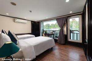 a hotel room with two beds and a balcony at Amanda Legend Cruise Ha Long Bay in Ha Long