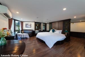 a hotel room with a large bed and a table at Amanda Legend Cruise Ha Long Bay in Ha Long