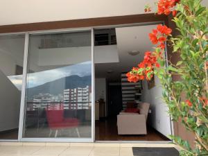 Habitación con puertas correderas de cristal y sofá en Confortable departamento tipo loft, en Quito