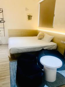 mały pokój z łóżkiem i stołem w obiekcie Beachcastle & Sea View Villa w mieście Magong