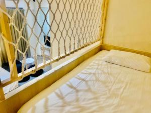 Cama pequeña en habitación con valla en Beachcastle & Sea View Villa, en Magong