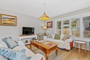 Sala de estar con 2 sofás y mesa en Sea views at Spring Beach Tasmanias East Coast, en Spring Beach