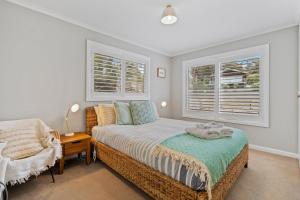 1 dormitorio con 1 cama y 2 ventanas en Sea views at Spring Beach Tasmanias East Coast, en Spring Beach