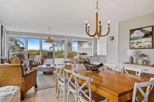uma sala de jantar e sala de estar com mesa e cadeiras em Sea views at Spring Beach Tasmanias East Coast em Spring Beach