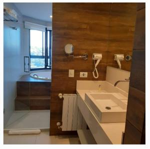 uma casa de banho com um lavatório, um chuveiro e uma banheira em Carpe Diem Boutique - Apart com banheira em Campos do Jordão