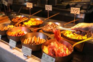 um buffet cheio de tigelas de comida com carne e legumes em InterContinental Sanya Resort, an IHG Hotel em Sanya