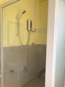 a bathroom with a shower with a phone on the wall at Café Darcey BnB in Tagbilaran City